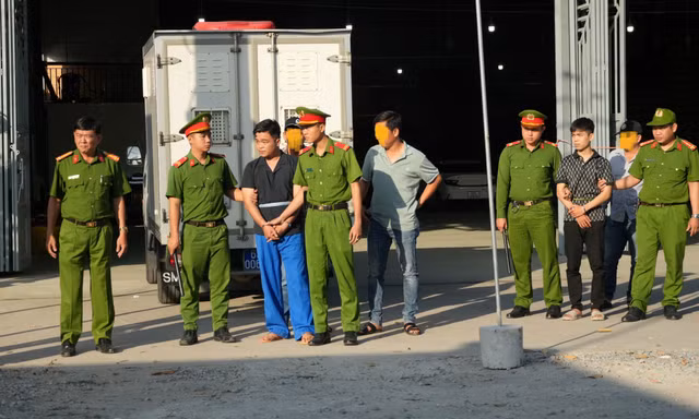 2 nghi phạm bị áp giải để dựng lại hiện trường.