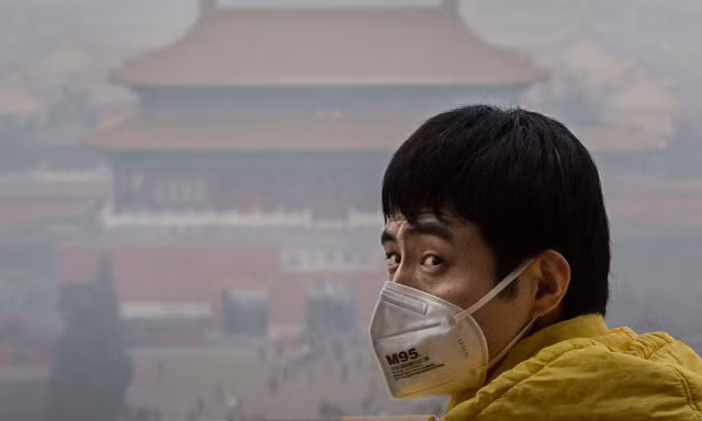 Một người đàn ông đeo khẩu trang giữa màn sương khói ô nhiễm ở Bắc Kinh