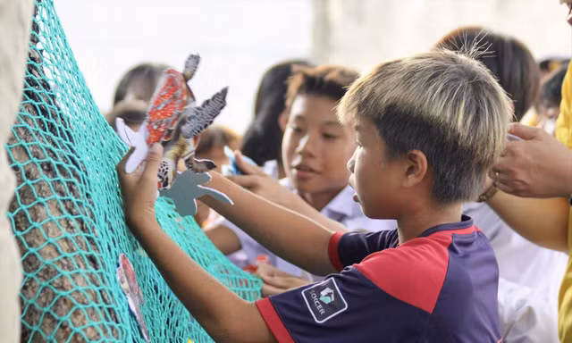 Các em nhỏ tham gia trò chơi giải cứu rùa biển để hiểu rõ về tác hại của những tấm lưới “ma”. Ảnh: NHẤT NGUYÊN