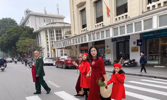 Một gia đình đi chụp ảnh ở Hồ Gươm ngày 27/1/2022. Ảnh: Như Ý