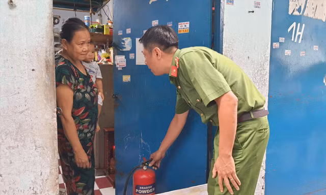 Công an TPHCM hướng dẫn người dân sử dụng bình chữa cháy tại phòng trọ ở quận Tân Phú. Ảnh: Hoàng Thuận