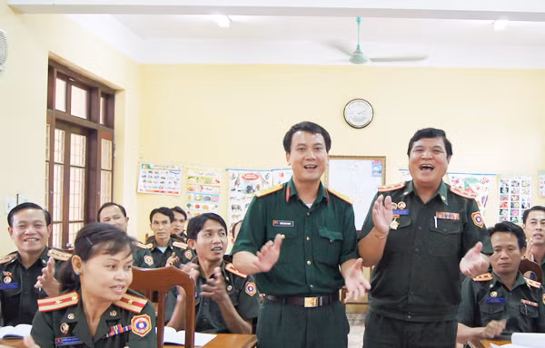 Trung tá Khon Sạ Vẳn (phải) và cán bộ Ban Thanh niên Quân đội Việt Nam bắt nhịp một bài hát tập thể tại lớp tập huấn Ảnh: N.S