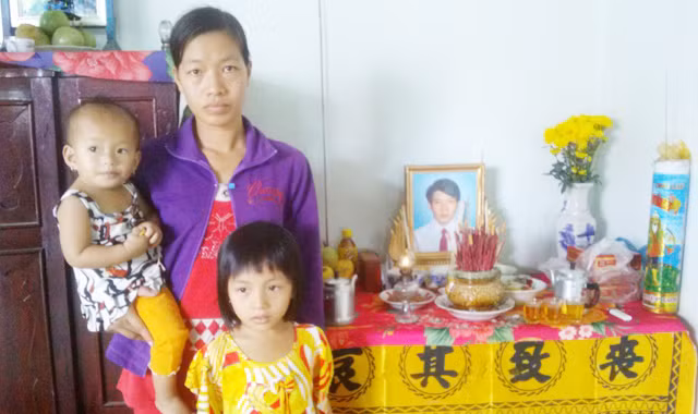 Vợ và con anh Sang trước di ảnh chồng. Ảnh: Hòa Hội.