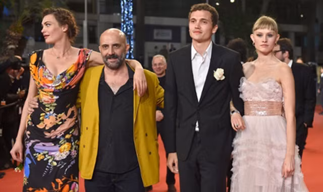 Đạo diễn Gaspar Nóe (áo vàng) và ba diễn viên chính phim "Love" trên thảm đỏ Cannes.