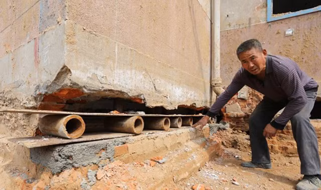 Một công nhân đặt tấm ván lên những ống sắt ngắn trong khe tường của một bệnh viên ở thành phố Trịnh Châu, tỉnh Hà Nam, Trung Quốc hôm 8/4.