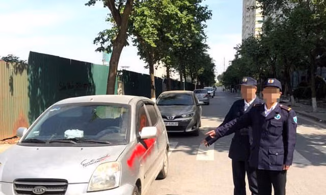 Nhóm bảo vệ xịt sơn vào xe ô tô đỗ dưới lòng đường.