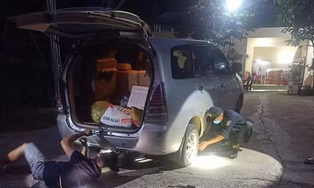 Cán bộ chốt kiểm soát dịch COVID-19 vá xe trong đêm cho người đi đường