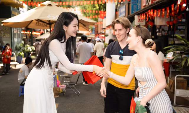 Thanh Thủy, Bùi Khánh Linh tặng cờ Tổ quốc cho khách quốc tế dịp đại lễ