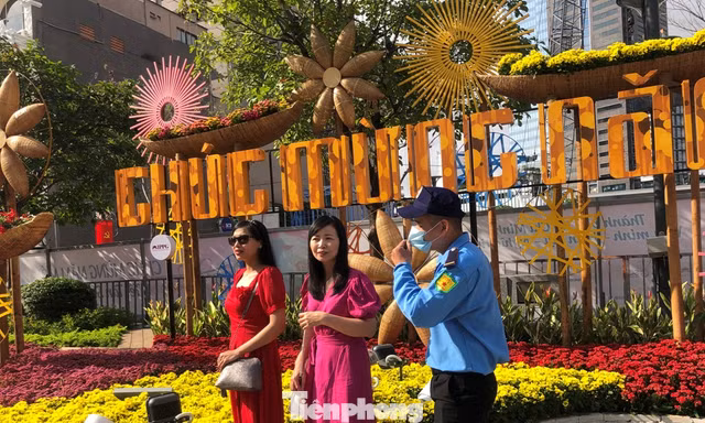 Du khách đến tham quan đường hoa Nguyễn Huệ phải đeo khẩu trang