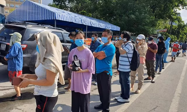 Người dân rồng rắn xếp hàng vào siêu thị mua thực phẩm. Ảnh: Uyên Phương