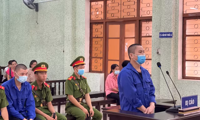 Bị cáo Nông Văn Hưởng (đứng) và Nông Ích Thạch ( áo xanh, ngồi) khai báo trước tòa -Ảnh: T.0