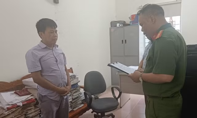 Đối tượng Nông Văn Thuận (bìa trái) nghe quyết định khởi tố bị can. Ảnh: CB