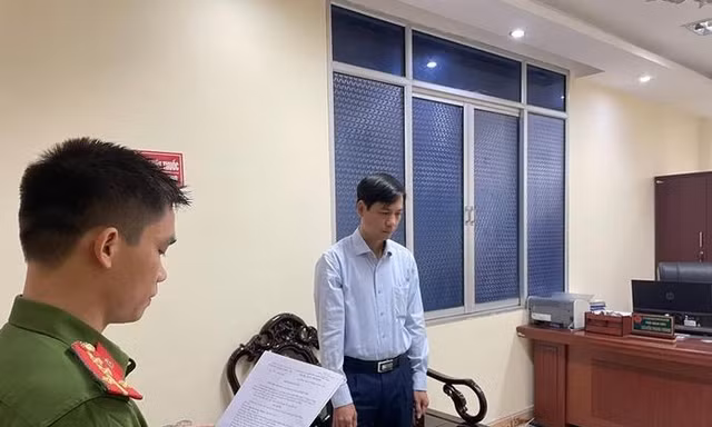 Ông Nguyễn Trọng Phùng (bìa phải) nghe lệnh khởi tố bị can .Ảnh: CB