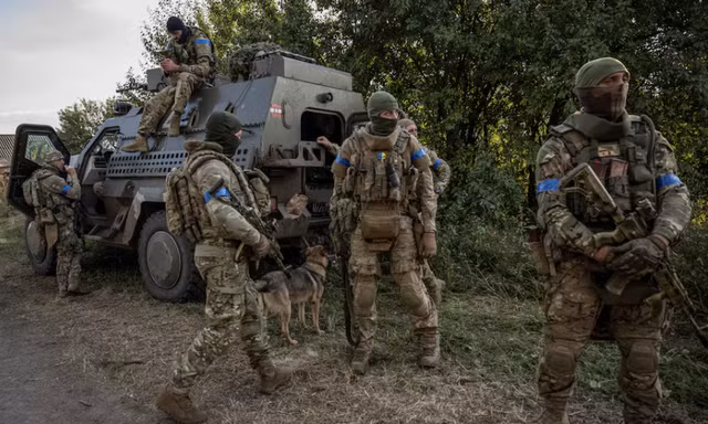 Lính Ukraine đứng gần chiếc xe quân sự ở khu vực gần biên giới Nga ngày 16/8. (Ảnh: Reuters)