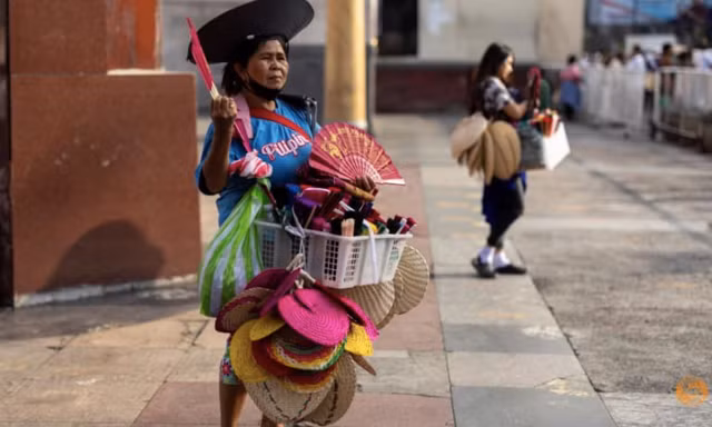 Một người bán quạt bên ngoài nhà thờ Quiapo trong ngày nắng nóng ở Manila, Philippines. (Ảnh: Reuters) 