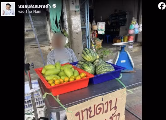 Người đàn ông treo biển rao bán mắt ở quầy trái cây. (Ảnh: ST)