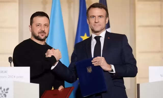 Tổng thống Pháp Emmanuel Macron và người đồng cấp Ukraine Volodymir Zelensky khi ký thỏa thuận an ninh tại Paris. (Ảnh: Reuters)