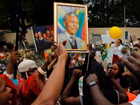 Người dân hát bên ngoài nhà cố tổng thống Nam Phi Nelson Mandela tại Johannesburg, hôm qua, mùng 9/12.