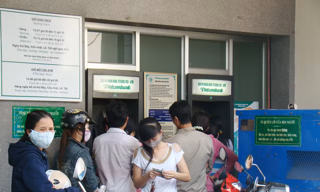 Người dân xếp hàng chờ rút tiền từ máy ATM của Vietcombank trên đường Đồng Khởi, phường Tân Phong, TP Biên Hoà sáng 26 Tết. Ảnh: Đức Minh