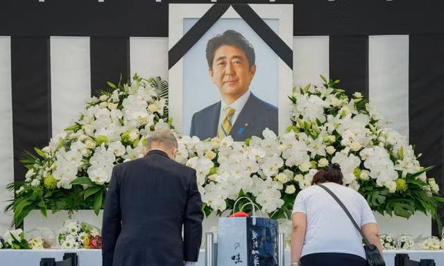 Người dân cúi đầu trước di ảnh cố Thủ tướng Abe Shinzo bên ngoài nhà thi đấu Nippon Budokan ở Tokyo. (Ảnh: Reuters)