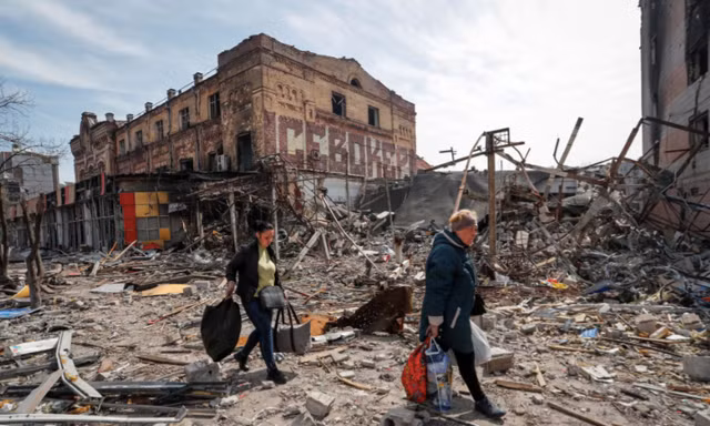 Người dân mang đồ rời khỏi thành phố Mariupol của Ukraine ngày 10/4. (Ảnh: Reuters)