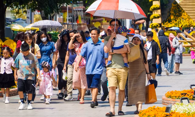 Nắng oi bức, người dân vẫn tranh thủ 'check-in' đường hoa Nguyễn Huệ ngày cuối