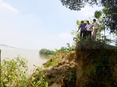 Hơn 1km đê quai đã hòa vào dòng nước, trơ lại những mỏm đất cao gần 10m Ảnh: T.V