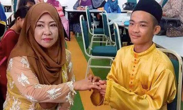 Chú rể 18 tuổi đeo nhẫn cưới vào tay cô dâu 42 tuổi trong đám cưới. Ảnh: Facebook.