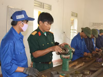 Thượng úy Đậu Bá Xuân (thứ 2, trái sang) đang hướng dẫn tổ sửa chữa ứng dụng sáng kiến mới