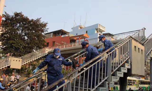 Nhân viên công ty vệ sinh môi trường đưa thi thể nam thanh niên xuống xe chở về nhà xác bệnh viện 