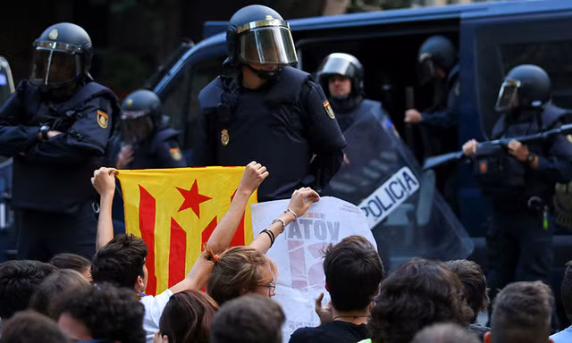 Cảnh sát Tây Ban Nha đàn áp người Catalan trong cuộc trưng cầu dân ý hôm 1/10. Ảnh: Reuters