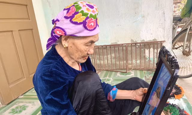 Mẹ Lưu Thị Linh bên di ảnh của liệt sỹ Hồ Văn Nuôi