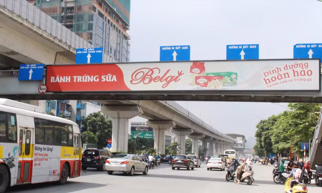 Quy định của thành phố Hà Nội, lắp biển quảng cáo mặt trong lan can để đảm bảo an toàn, nhưng các biển quảng cáo của Vinasing trên cầu vượt đã lắp ở mặt ngoài Ảnh: A.Trọng 
