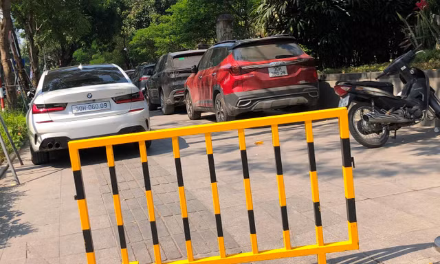 Chủ bãi xe trên vỉa hè Huỳnh Thúc Kháng được rào chắn, bịt vỉa hè để trông ô tô sai quy định. Ảnh: Anh Trọng