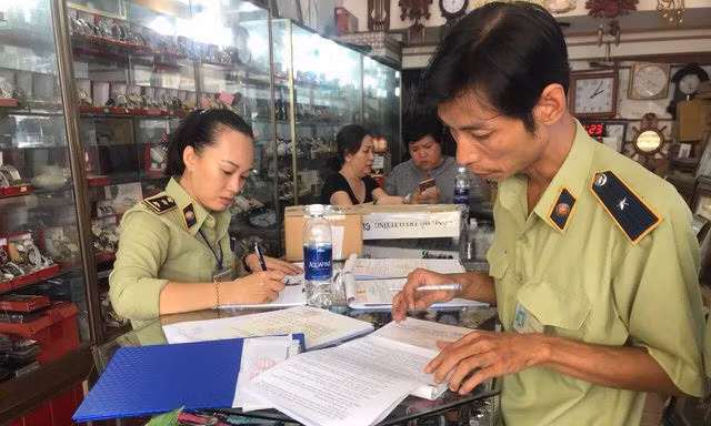 Lực lượng quản lý thị trường làm việc tại một cửa hàng 