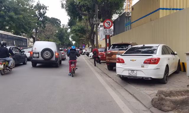 Ô tô đỗ "ngay ngắn" trên vỉa hè trước cổng đền Kim Liên (quận Đống Đa, Hà Nội)
