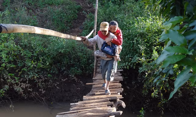 Chồng thót tim cõng vợ bại liệt băng qua cầu ọp ẹp mỗi ngày