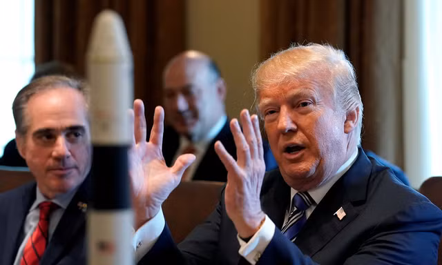 Ông Trump trò chuyện tại Nhà Trắng với mô hình tàu vũ trụ đặt trên bàn. Ảnh: Reuters