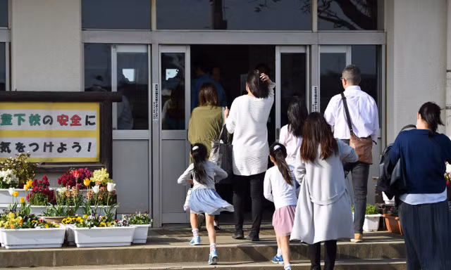Các phụ huynh đến trường tiểu học Mutsumi số 2 ở quận Chiba để tham dự buổi họp phụ huynh khẩn. Ảnh: Mainichi