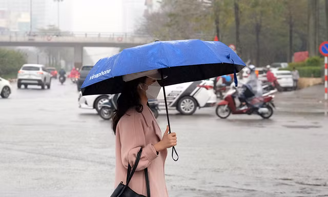 Người dân Thủ đô 'vật lộn' với thời tiết mưa phùn, nồm ẩm