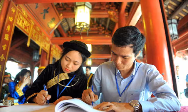 Tiến sĩ Vòng Bính Long ghi sổ vàng tại Văn Miếu - Quốc Tử Giám chiều 11/11. Ảnh: Xuân Tùng