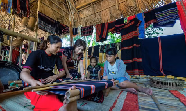 Trần Thị Một (thứ 2 từ trái sang) hướng dẫn các bạn trẻ cách dệt thổ cẩm truyền thống của người Cơ Tu. Ảnh: NVCC