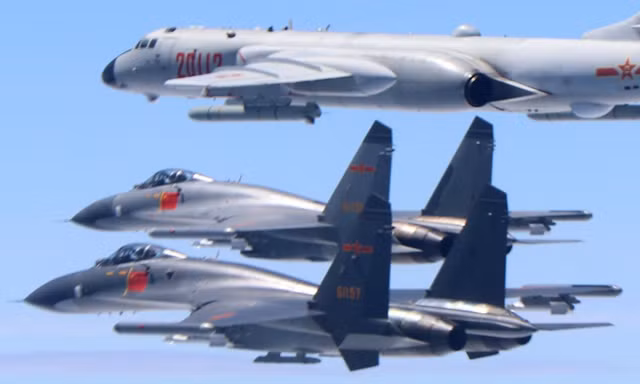 Hai máy bay chiến đấu J-11 và một máy bay ném bom H-6K của Không quân Trung Quốc bay giữa đại lục và Đài Loan. Ảnh: Tân Hoa Xã
