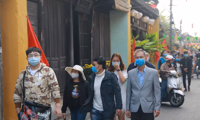Khách du lịch đeo khẩu trang khi tham quan phố cổ Hội An 