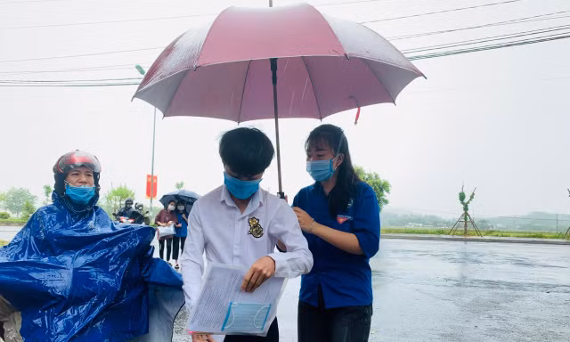 Cảm động tình nguyện viên che ô cho thí sinh giữa trời mưa lớn