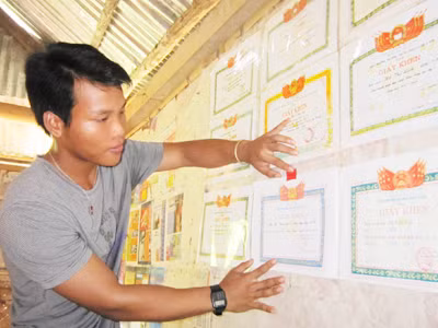 Cậu học trò Pakoh Hồ Văn Sợi bên những tấm giấy khen Ảnh: Q.M