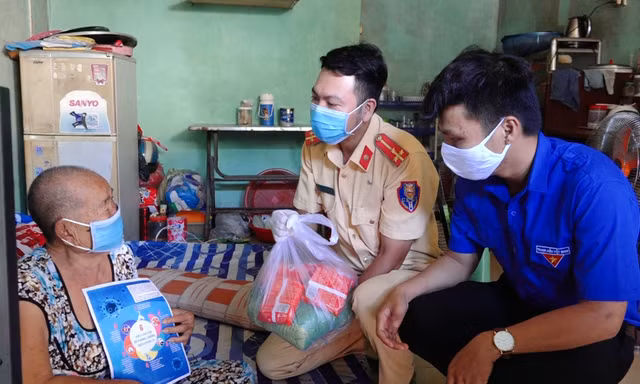 Các chiến sĩ CSGT tặng quà cho người nghèo.