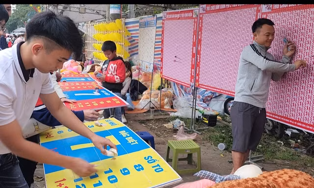 Du khách đặt tiền chơi trò ném phi tiêu cộng điểm trúng thưởng tại Khu du lịch- di tích Đền Sóc