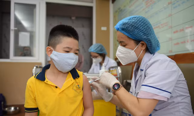 Nhân viên y tế tiêm vaccine COVID-19 cho trẻ trong độ tuổi