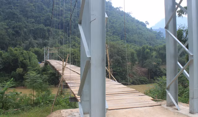 Cầu treo xã Trung Xuân, huyện Quan Sơn (Thanh Hóa) đang bị nhiều lỗi kỹ thuật, chưa xây dựng xong, nhưng người dân vẫn qua lại trên cầu. Ảnh: Hoàng Lam